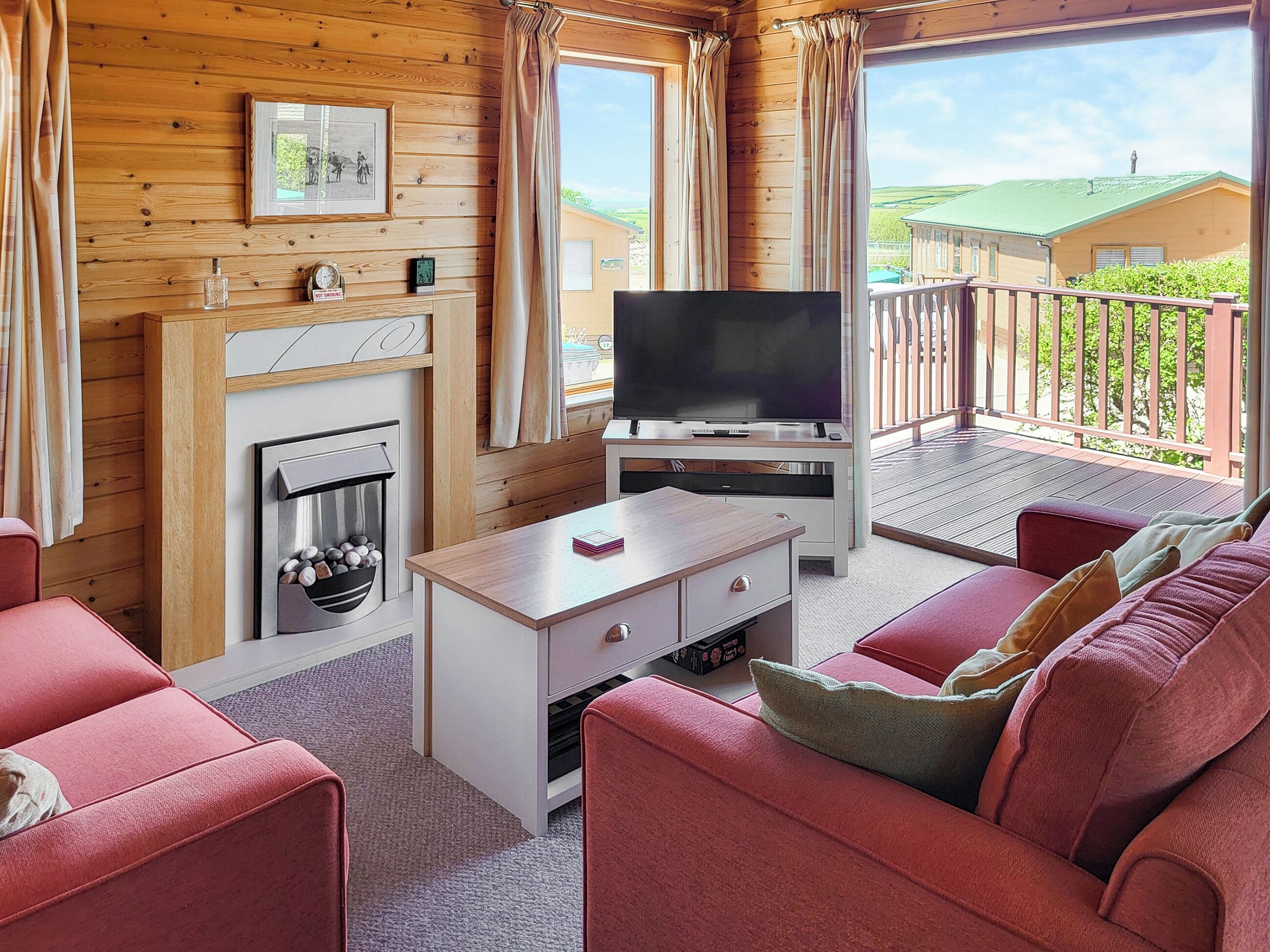 A cozy room with a fireplace, a flat-screen TV, and a sofa.