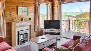 Ett mysigt rum med en öppen spis, en platt-TV och en soffa.