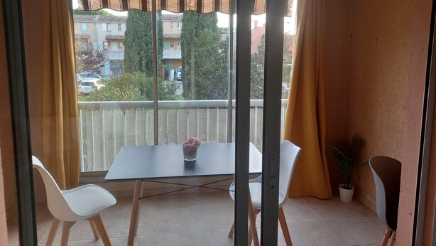 A balcony with a table, two chairs, and a potted plant. - Beau Studio Mar Vivo (La Seyne-sur-Mer)
