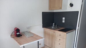 A compact kitchen with a sink, a small countertop, and a red appliance. - Beau Studio Mar Vivo (La Seyne-sur-Mer)