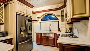 A kitchen with a stainless steel refrigerator, a built-in oven, a sink, and wooden cabinets. - Le'Lavion's Pool Villa w/Airport svc. & Private Chef/Ocho Rios Tower Isle (Ocho, Rios, Jamaca)