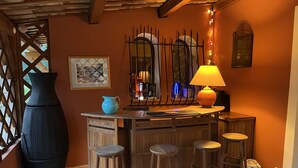 Een bar met krukken, een lamp en een grote vaas.