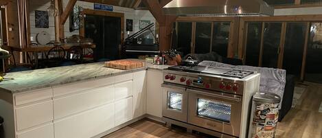 Una cocina con estufa, horno y armarios de madera.