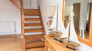 A wooden staircase, a wooden desk with a mirror, and two sailboats. - Egret (Milford Haven)