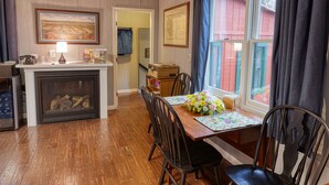 A dining area with a wooden table, chairs, and a fireplace.