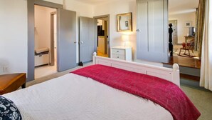 A bedroom with a bed, a nightstand, a dresser, a mirror, and a door leading to another room. - Cozy Country Getaway in the Heart of Upperville  (Upperville)
