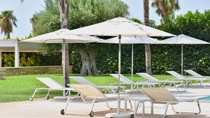 A poolside area with lounge chairs and umbrellas.