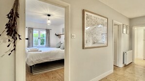Un dormitorio con cama, radiador y un cuadro en la pared.