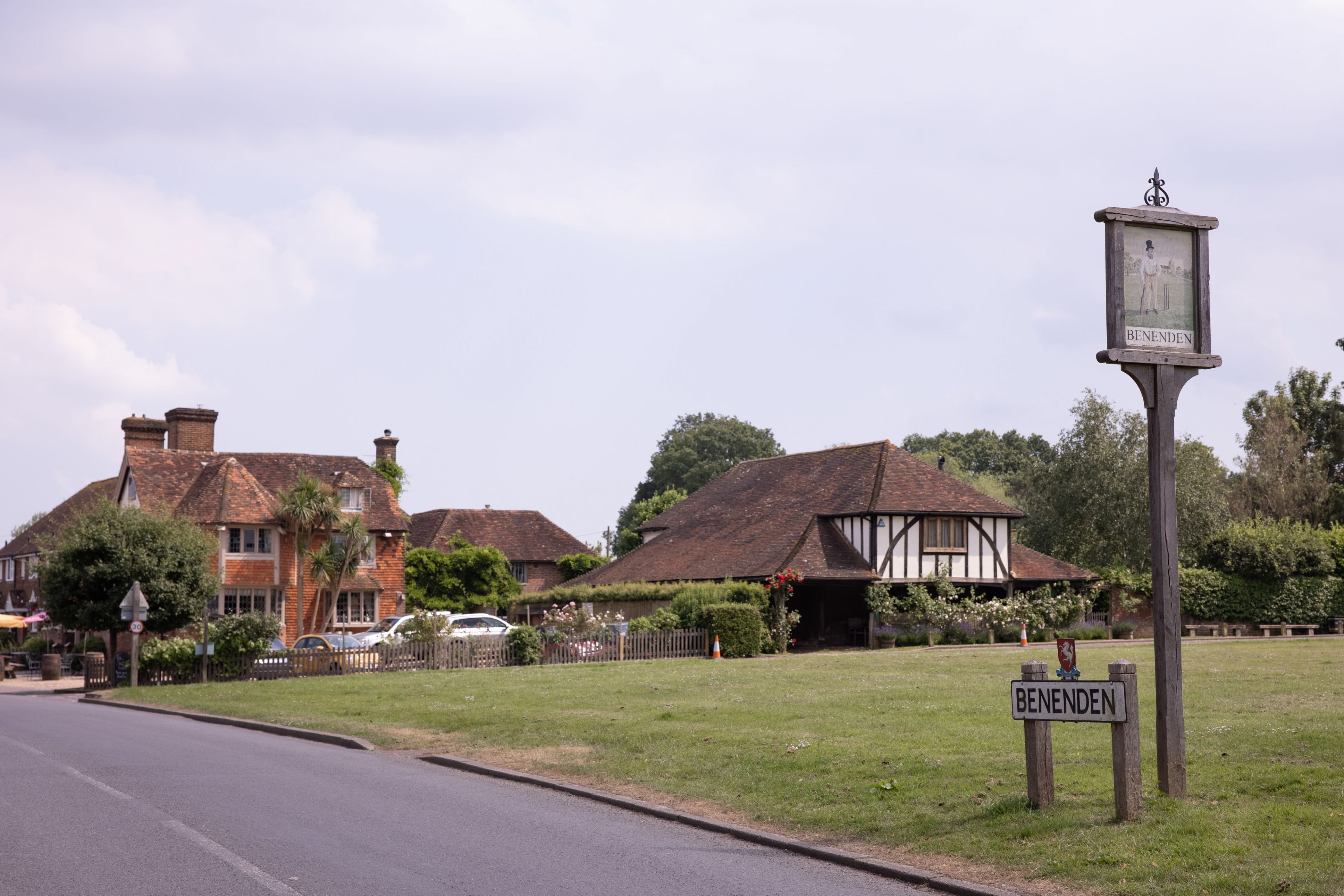 A traditional English village with a sign reading "BENENDEN" and a pub with a thatched roof.