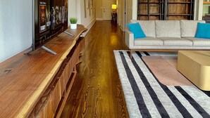 A hallway with a wooden bench, a sofa, and a striped rug. - Upscale Downtown Luxury Penthouse with PARKING (Macon)