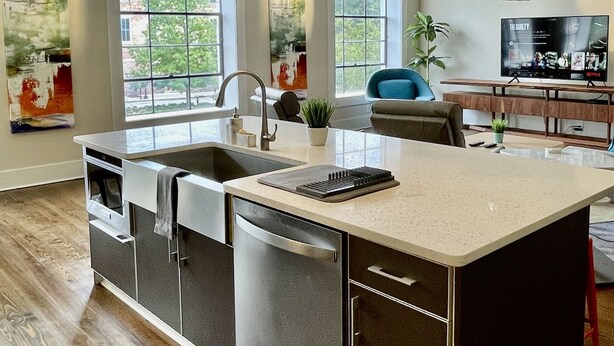 A modern kitchen with a central island, built-in appliances, and large windows. - Upscale Downtown Luxury Penthouse with PARKING (Macon)