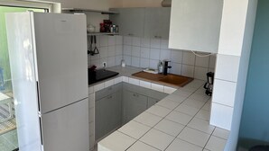 A compact kitchen with a refrigerator, a sink, and a countertop. - Villa Oasis Garden Apartment (Collectivity of Saint Martin)