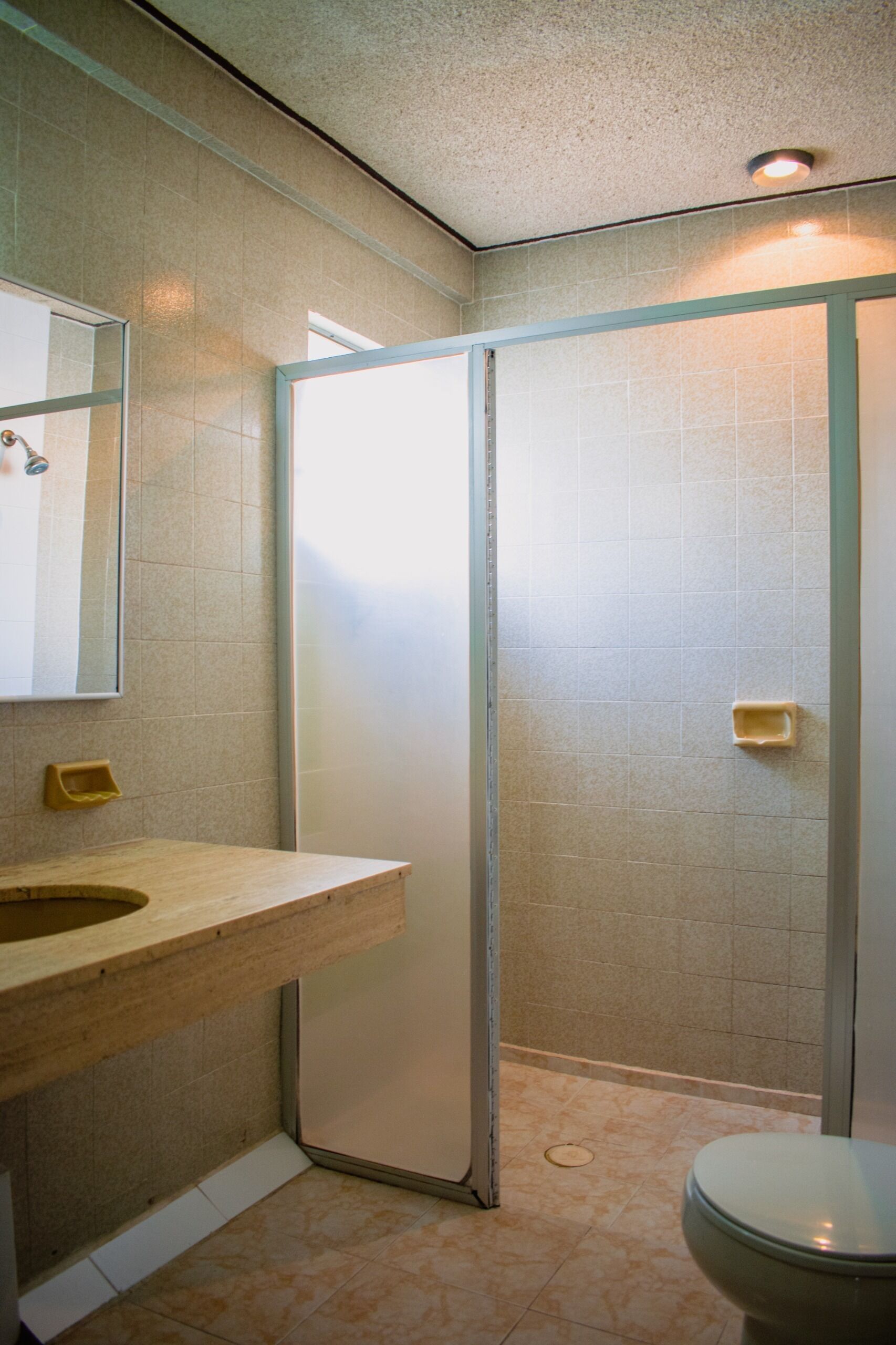 A bathroom with a shower, toilet, and sink.