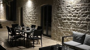 Enjoy dining al fresco in this inviting outdoor space with a table set for a meal, surrounded by comfortable seating and a sofa.
