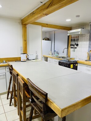 Een microgolfoven, een oven, een kookplaat, kookgerei, borden en bestek