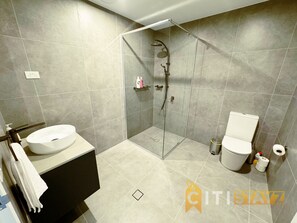 A modern bathroom with a glass-enclosed shower, a white sink, and a toilet. - Lavish in Lyneham - 2BD 1BTH Apt (Lyneham)