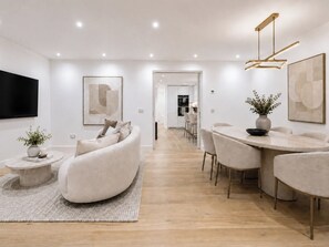 Un salon moderne comprenant un canapé, une table basse et un coin repas avec des chaises et une table.