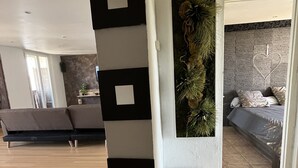 A modern living room with a sofa, a coffee table, and a decorative wall piece.