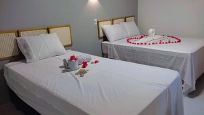 Two single beds with white linens, each with a headboard and a pillow. - Pousada Essência de Atins (Barreirinhas)
