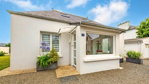 Un bâtiment blanc avec un panneau portant le numéro 13, une fenêtre et une porte.