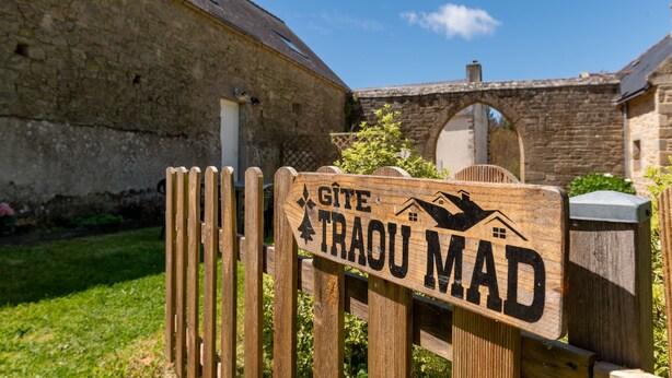 A wooden sign with the text 'GITE TRAOU MAD' and a house icon.