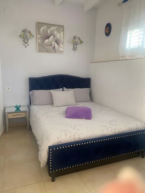 Une chambre à coucher comprenant un lit, une table de chevet et des éléments décoratifs sur les murs.