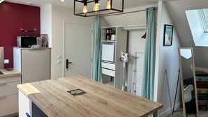 Una cocina moderna con una mesa de madera, un microondas y una lámpara en el techo.