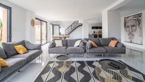 A modern living room with two grey sofas, a patterned rug, and a staircase leading to an upper level. - Holiday Home 'Villa Nina' with Mountain View, Wi-Fi and Air Conditioning (Mirepeisset)