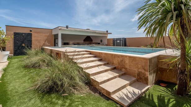 A modern outdoor pool area with a stone deck, a covered seating area, and a stone wall. - Holiday Home 'Villa Nina' with Mountain View, Wi-Fi and Air Conditioning (Mirepeisset)