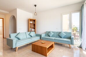 A modern living room with a sectional sofa, a wooden coffee table, and a bookshelf.