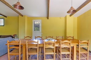 A dining area with a wooden table and chairs, a window with a view, and a door.