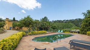 A swimming pool with a curved edge, surrounded by a tiled patio. - Country House 'Can Marc' with Mountain View, Private Pool and Wi-Fi (Dosrius)