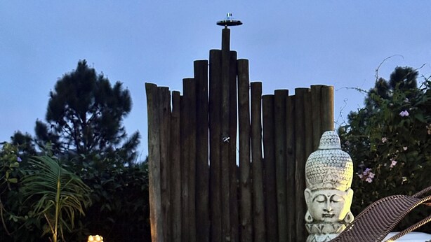 A wooden deck with a pool, a Buddha statue, and a carved pumpkin. - Altos da Lagoa-praia do Rosa,ibiraquera Studio 1 Para Casais Calmo e Tranquilo (imbituba)