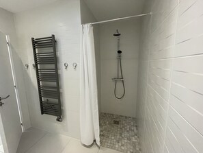 Een douche, handdoeken, zeep, shampoo