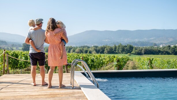 A wooden deck with a pool, overlooking a vineyard and mountains. - Quinta Vila Nova | Apartamento das Camélias | Agrotourism | Rural Environment (Monção)
