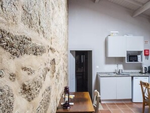 Een koelkast, een magnetron, een oven, kookgerei, borden en bestek