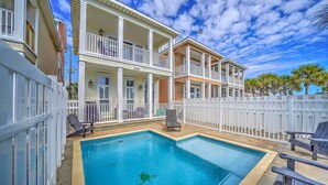 A two-story house with a pool, white railings, and a white fence. - 4806 Hispaniola St. 3 Kings - 4 Twins - Private Heated Pool! 2 Minute Walk to the Sand! (Panama City Beach)