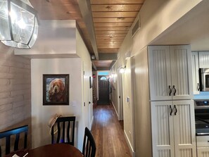 Enter a cozy dining area with a table and chairs, leading to a kitchen with modern cabinetry and a stainless steel oven.