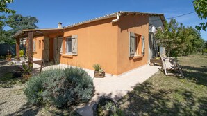 A two-story house with a tiled roof, a front porch, and a small garden with various plants. - Holiday Home 'Isula Paradise' with Mountain View, Private Terrace (LINGUIZZETTA)