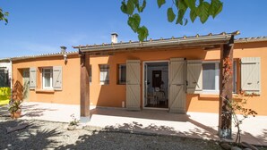 A two-story house with a front porch, a small garden, and a clear blue sky. - Holiday Home 'Isula Paradise' with Mountain View, Private Terrace (LINGUIZZETTA)