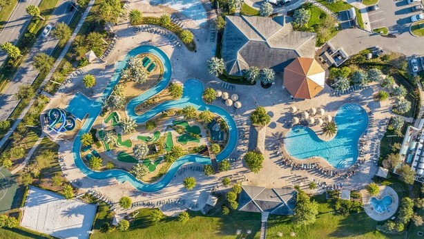 An aerial view of a resort with multiple swimming pools, a golf course, and a large parking area. - Spacious Home,Private Pool-September Special Price (Kissimmee)