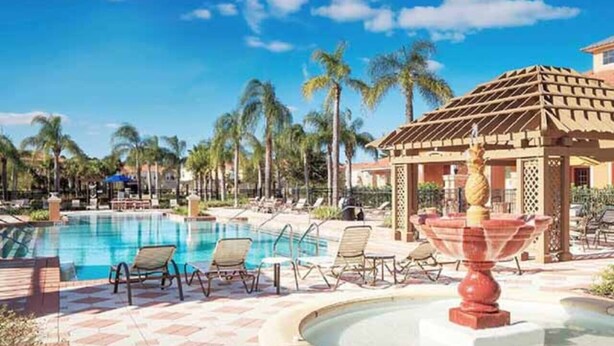 A pool area with lounge chairs and a fountain. - Mandalorian Retreat – Private Pool Near Disney (Kissimmee)