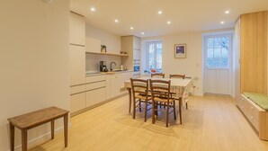 Una cocina moderna con comedor, piso de madera y un banco empotrado.