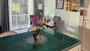 A modern kitchen with a central island, pendant lights, and a dining area with a table and chairs. - Christmas in the FL Keys!!! Stunning sunsets, beaches 10 min away, Fishing!!! (Big Pine Key)