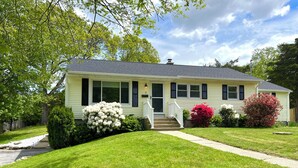 A single-story house with a front porch, a chimney, and a well-maintained lawn. - Hot Tub & Cloud Ceiling House (Montville)