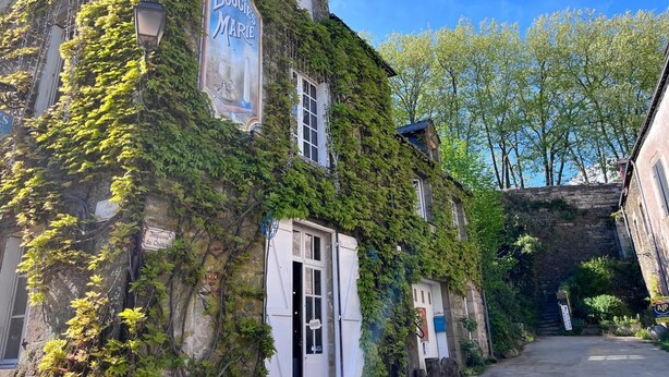 A building with ivy-covered walls and a sign reading 'BOUGIES MARIE'. - La Grée des Dinosaures (SAINT GRAVE)
