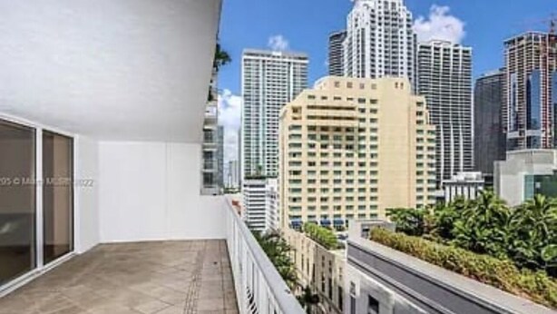 Un balcon avec vue sur la ville, un sol carrelé et une balustrade.