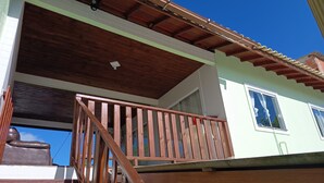 Un edificio de dos pisos con balcón de madera y tejado de tejas.