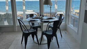 A dining area with a table set for four, overlooking the ocean. - Modern Mid-Century Cabin, on the beach, with views of the San Juan Islands! (Oak Harbor)