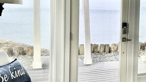A room with a white door leading to a balcony overlooking the sea. - Modern Mid-Century Cabin, on the beach, with views of the San Juan Islands! (Oak Harbor)